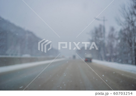 Winter road on a snowy day. Focus on the snow Winter road on a snowy day. Focus on the snow 60703254