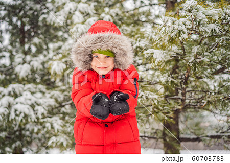 Happy boy plays with snow. Cute kid throwing snow in a winter park. Happy winter holidays. Winter 60703783