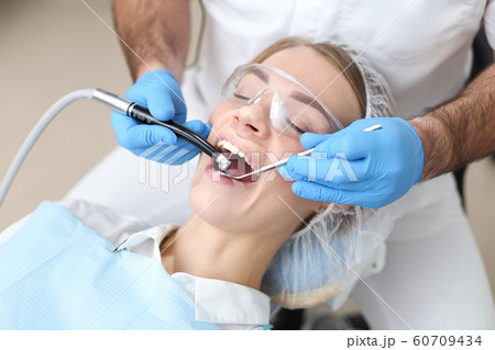 Dentist examines teeth of female patient. Selective focus. 60709434