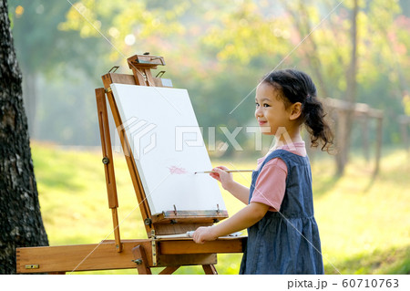 Lovely little girl show happy smile and enjoy with painting in the garden Lovely little girl show happy smile and enjoy with painting in the garden 60710763