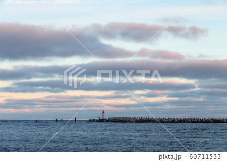 Seascape at sunrise with a lighthouse in the 60711533