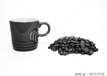 Black and white cup of coffee by a pile of coffee Black and white cup of coffee by a pile of coffee 60712529