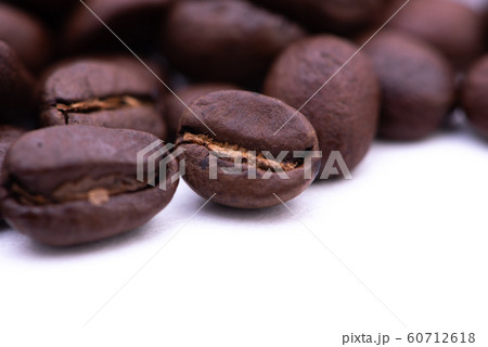 Close up of coffee beans on a white background Close up of coffee beans on a white background 60712618