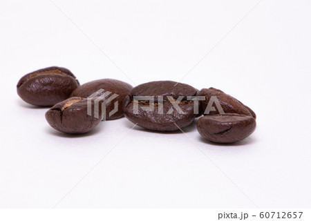 Close up of coffee beans on a white background Close up of coffee beans on a white background 60712657