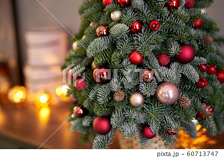 Beautiful small Christmas tree on wooden table. Happy mood. Garland lamp bokeh on background. Wallpaper. Danish pine and fir, Nobilis Beautiful small Christmas tree on wooden table. Happy mood. Garland lamp bokeh on background. Wallpaper. Danish pine and fir, Nobilis 60713747