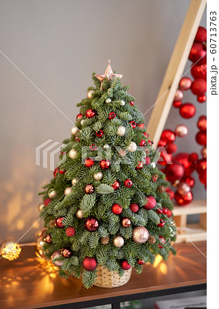 Beautiful small Christmas tree on wooden table. Happy mood. Garland lamp bokeh on background. Wallpaper. Danish pine and fir, Nobilis Beautiful small Christmas tree on wooden table. Happy mood. Garland lamp bokeh on background. Wallpaper. Danish pine and fir, Nobilis 60713763