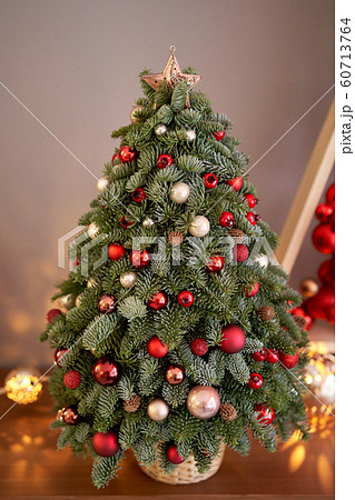 Beautiful small Christmas tree on wooden table. Happy mood. Garland lamp bokeh on background. Wallpaper. Danish pine and fir, Nobilis 60713764