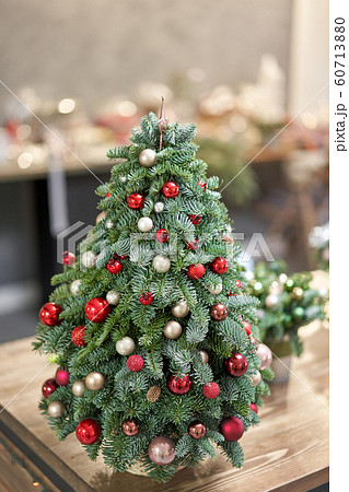 Beautiful small Christmas tree on wooden table. Happy mood. Garland lamp bokeh on background. Wallpaper. Danish pine and fir, Nobilis Beautiful small Christmas tree on wooden table. Happy mood. Garland lamp bokeh on background. Wallpaper. Danish pine and fir, Nobilis 60713880