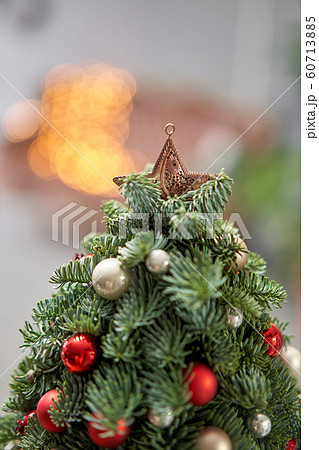 Beautiful small Christmas tree on wooden table. Happy mood. Garland lamp bokeh on background. Wallpaper. Danish pine and fir, Nobilis Beautiful small Christmas tree on wooden table. Happy mood. Garland lamp bokeh on background. Wallpaper. Danish pine and fir, Nobilis 60713885
