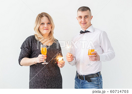 Holidays, christmas, valentine's day and new year concept - Woman and man celebrate and holds wine in a glass over white background 60714703