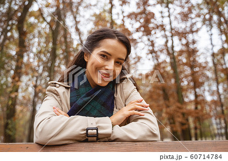 Beautiful young female leaning on the bench 60714784