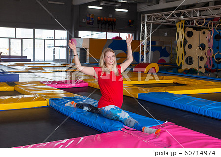 fitness, sport, exercising, stretching and people concept - smiling woman doing splits on mat over gym background fitness, sport, exercising, stretching and people concept - smiling woman doing splits on mat over gym background 60714974