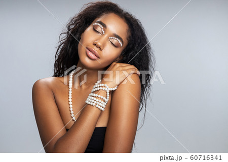 Relaxed woman with startling makeup posing for camera Relaxed woman with startling makeup posing for camera 60716341