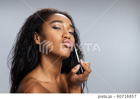 Amazing lady applying lip gloss in studio Amazing lady applying lip gloss in studio 60716857