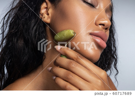 Nice attractive lady making facial massage in studio 60717689