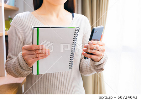 スマホとノートを持つ女性 スマホとノートを持つ女性 60724043