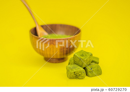 Matcha powder and candy made of matcha on yellow background. Homemade Matcha Matcha powder and candy made of matcha on yellow background. Homemade Matcha 60729270