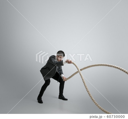 Caucasian man in office clothes training isolated on grey studio background Caucasian man in office clothes training isolated on grey studio background 60730000