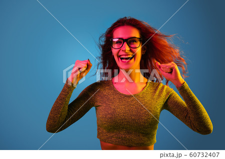 Caucasian woman's portrait isolated on blue studio background in neon light 60732407