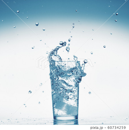 one glass of water with splash from falling ice 60734259
