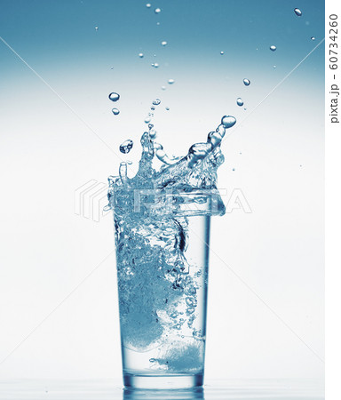 one glass of water with splash from falling ice one glass of water with splash from falling ice 60734260