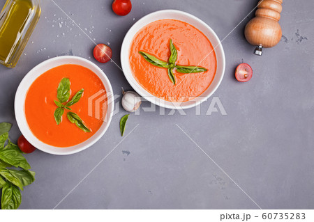 Tomato soup in bowls on gray stone table Tomato soup in bowls on gray stone table 60735283