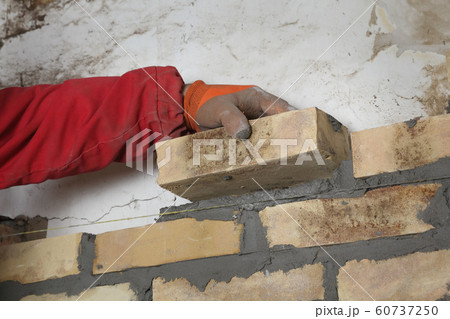 Worker building brick wall 60737250