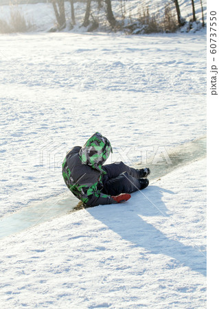 Boy Sliding on Ice Rink Boy Sliding on Ice Rink 60737550