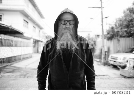 Mature bald man with long gray beard wearing sunglasses outdoors Mature bald man with long gray beard wearing sunglasses outdoors 60738231