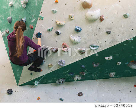 A woman climbing in boulder gym in the wall. A woman climbing in boulder gym in the wall. 60740618