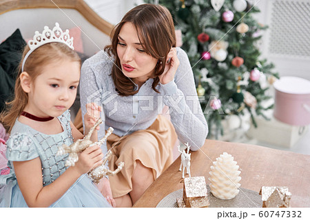 Cheerful mom embraces her cute baby daughter . Parent and little child having fun near Christmas tree indoors. Loving family Merry Christmas and Happy New Year Cheerful mom embraces her cute baby daughter . Parent and little child having fun near Christmas tree indoors. Loving family Merry Christmas and Happy New Year 60747332