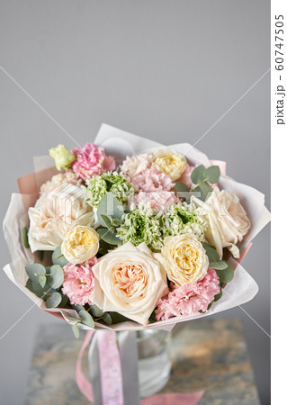 European floral shop. Beautiful bouquet of mixed flowers in glas vase. the work of the florist at a flower shop. Delivery fresh cut flower. European floral shop. Beautiful bouquet of mixed flowers in glas vase. the work of the florist at a flower shop. Delivery fresh cut flower. 60747505