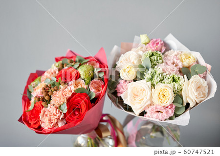 European floral shop. Beautiful bouquet of mixed flowers in glas vase. the work of the florist at a flower shop. Delivery fresh cut flower. 60747521