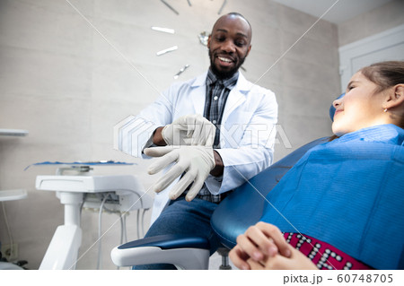 Young caucasian girl visiting dentist's office Young caucasian girl visiting dentist's office 60748705