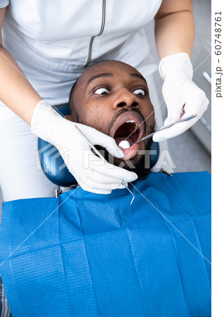 Young african-american man visiting dentist's office 60748761