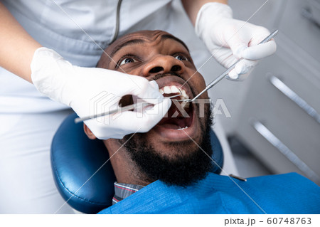 Young african-american man visiting dentist's office 60748763