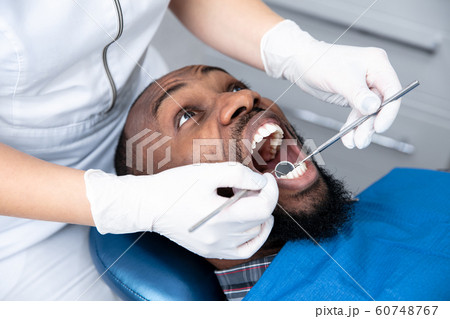 Young african-american man visiting dentist's office 60748767