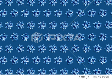 Christmas pink background with circle frame of blue bows. 60751956