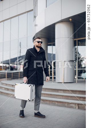 Handsome businesman in a summer city Handsome businesman in a summer city 60752062