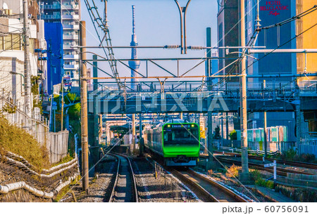 日本の東京都市景観 大塚駅を出発した電車と東京スカイツリーなどを望むの写真素材
