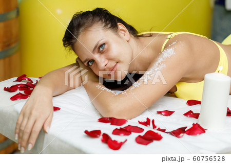 Woman brunette getting salt scrub treatment in spa 60756528