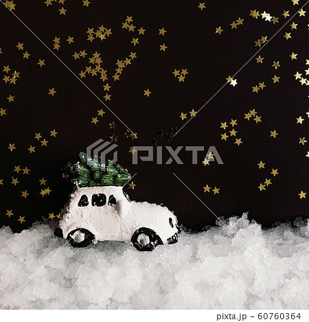 A miniature white toy car carries a Christmas tree A miniature white toy car carries a Christmas tree 60760364