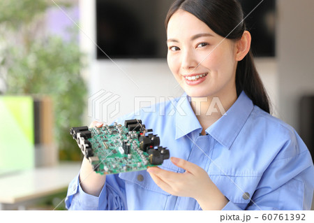 基板を見せる笑顔の女性エンジニア1 基板を見せる笑顔の女性エンジニア1 60761392