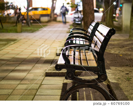 benches on pavement in light lantern at night 60769100