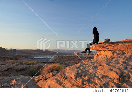 グレンキャニオンダムで夕日を見る女性 60769619