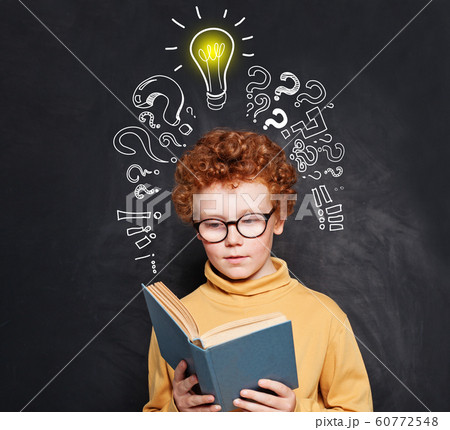 Child reading on blackboard background Child reading on blackboard background 60772548