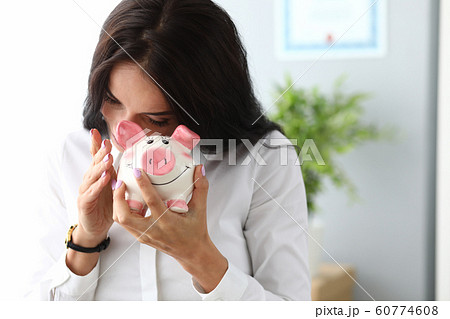 Pretty lady holding home bank 60774608