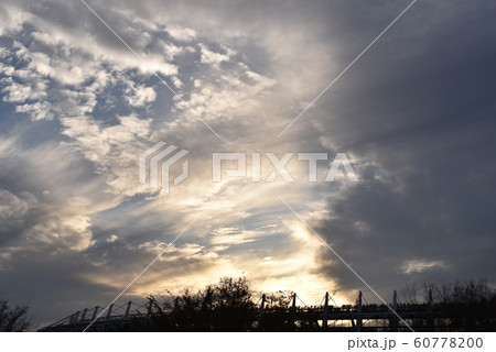 空に広がる雲に反射する夕日と 味の素スタジアム 東京スタジアム の屋根の鉄柱の写真素材