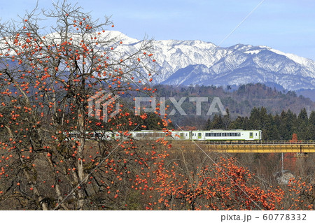 晩秋の磐越西線と雪化粧の飯豊連峰 60778332