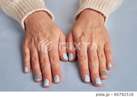 Delicate blue manicure on a fabric background. Delicate blue manicure on a fabric background. 60782516